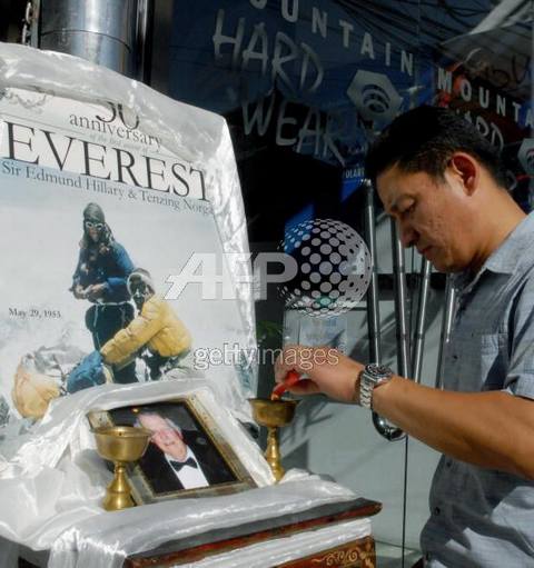 El hijo de Tenzing Norgay le ofrece una veladora votiva a los conquistadores del Everest: su padre y Edmund Hillary, el 11 de enero de 2008